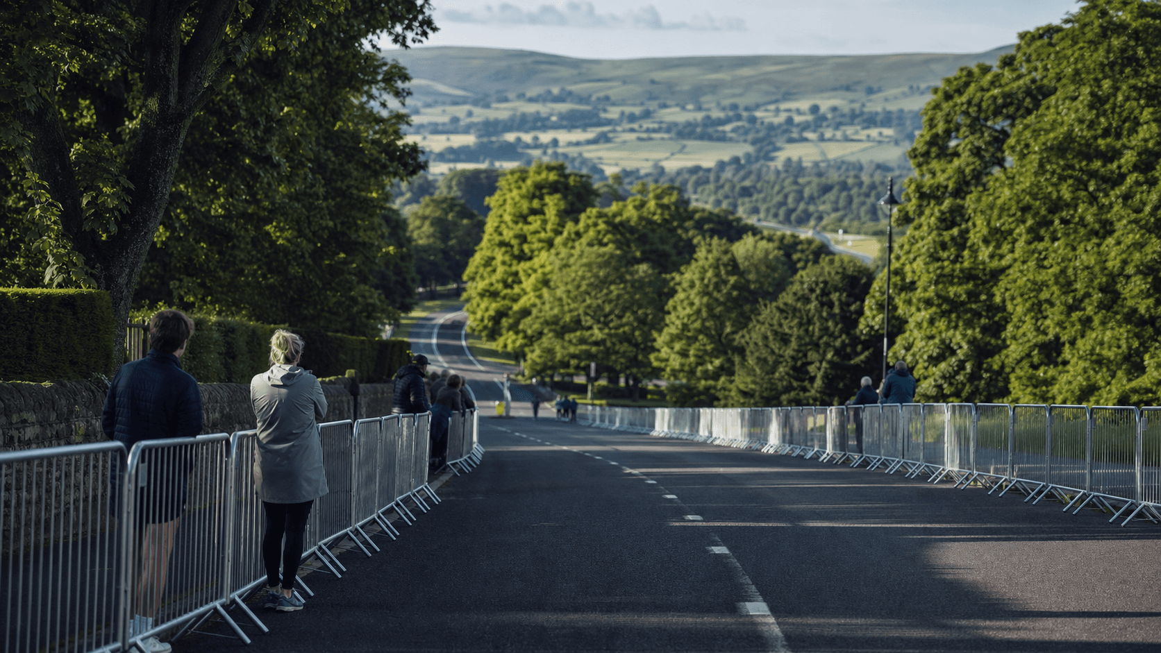 Closed rural Yorkshire road leading from a green park towards rolling hills